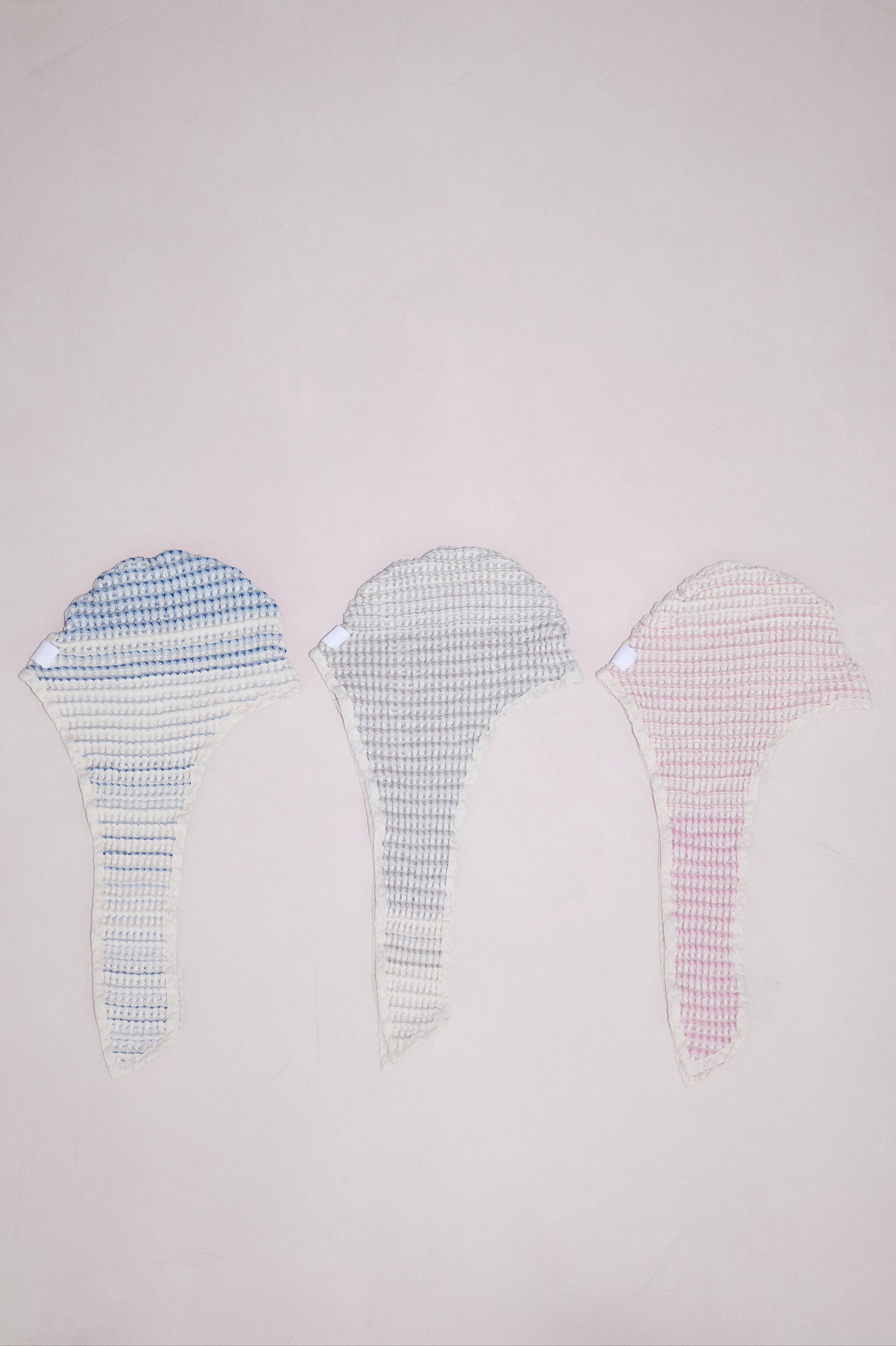 Baby bath bonnet laid flat to reveal size and hood shape in all colors - tide, sand, and shell