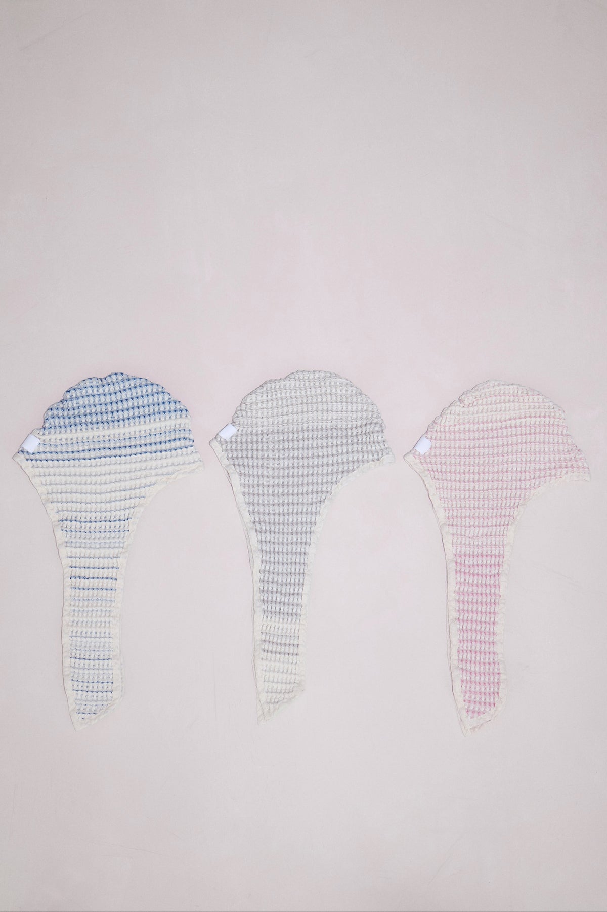 Baby bath bonnet laid flat to reveal size and hood shape in all colors - tide, sand, and shell