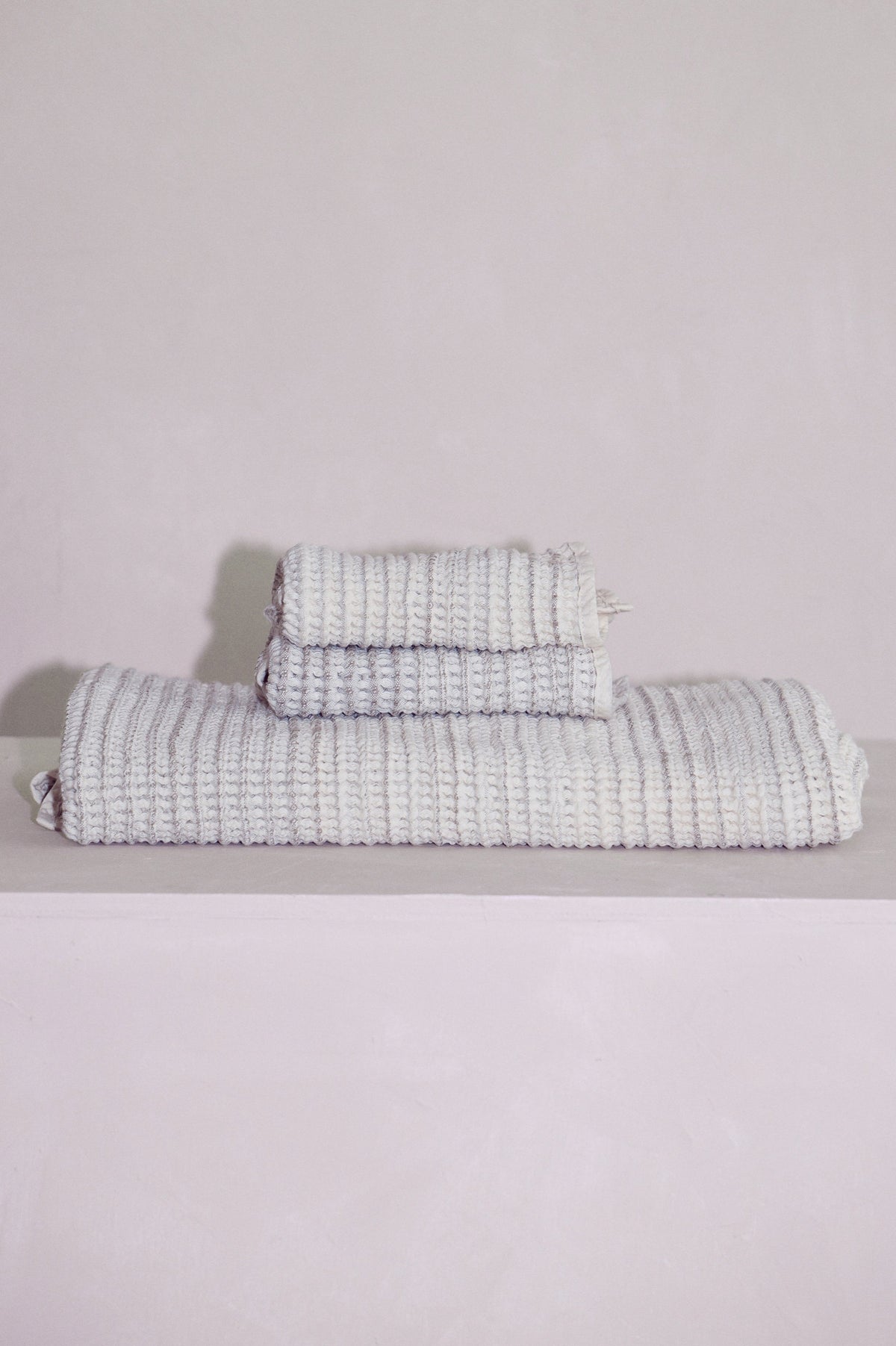 Stacked Sand baby receiving towel and washcloths highlighting absorbent natural fibers