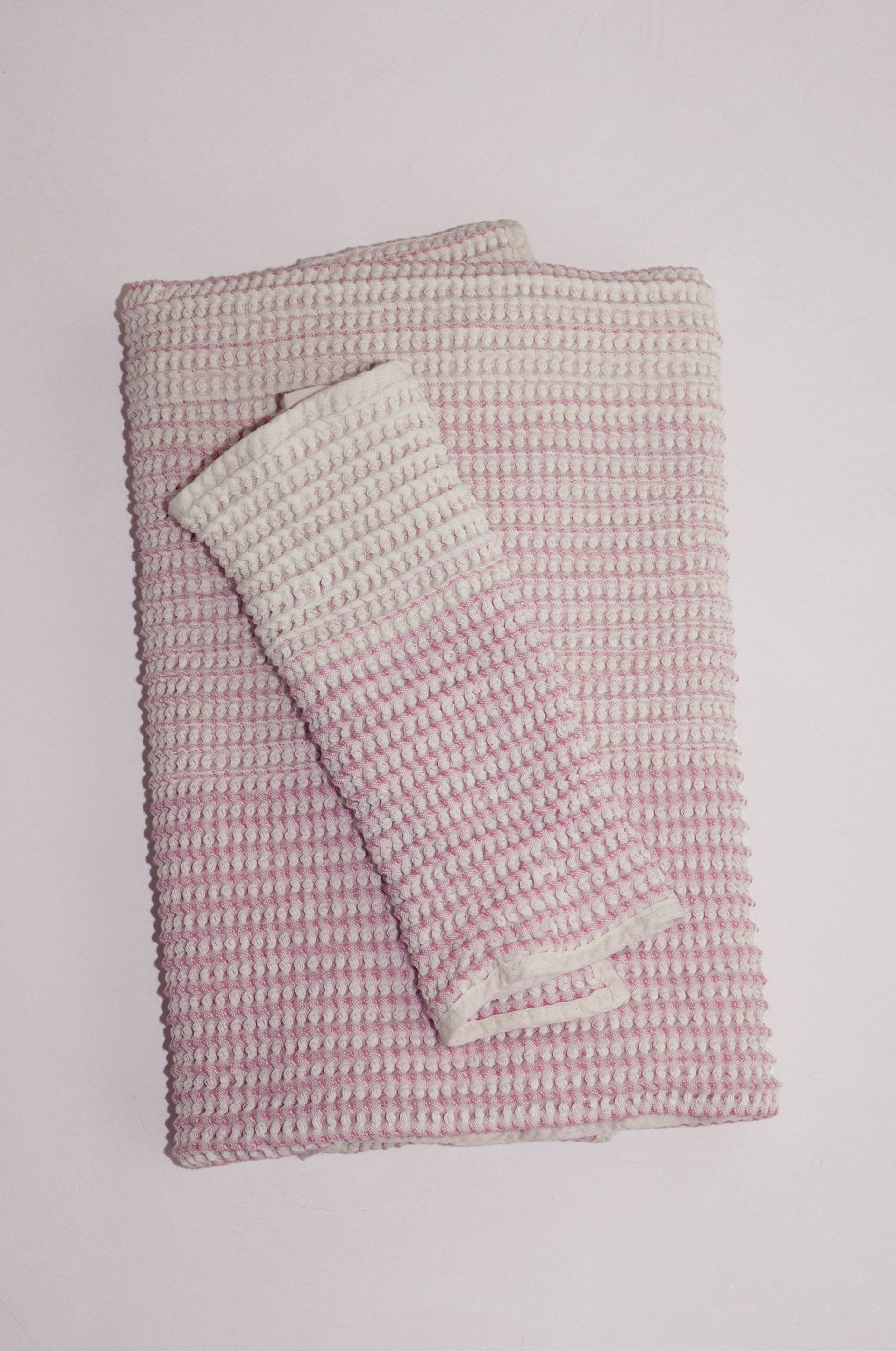 Shell-colored cotton receiving baby towel set folded on neutral backdrop