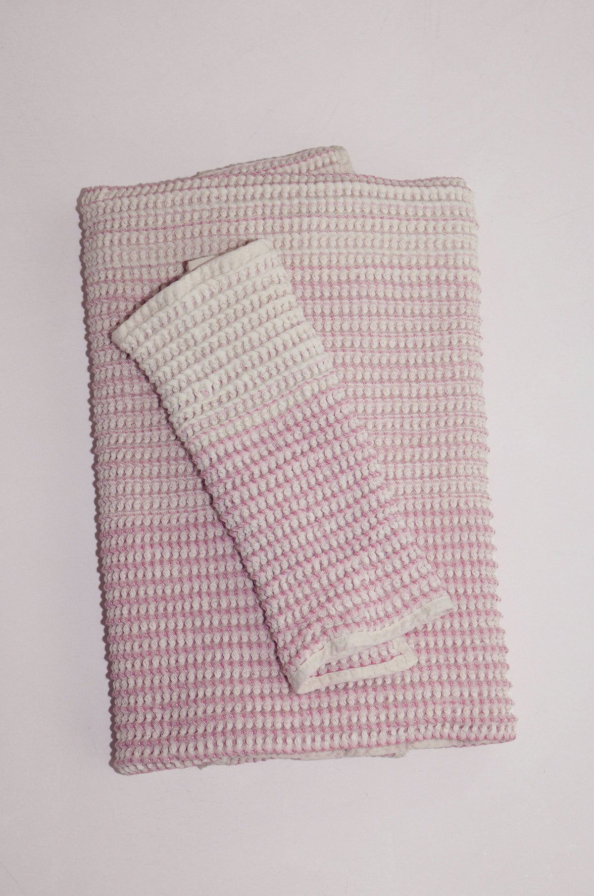 Shell-colored cotton receiving baby towel set folded on neutral backdrop