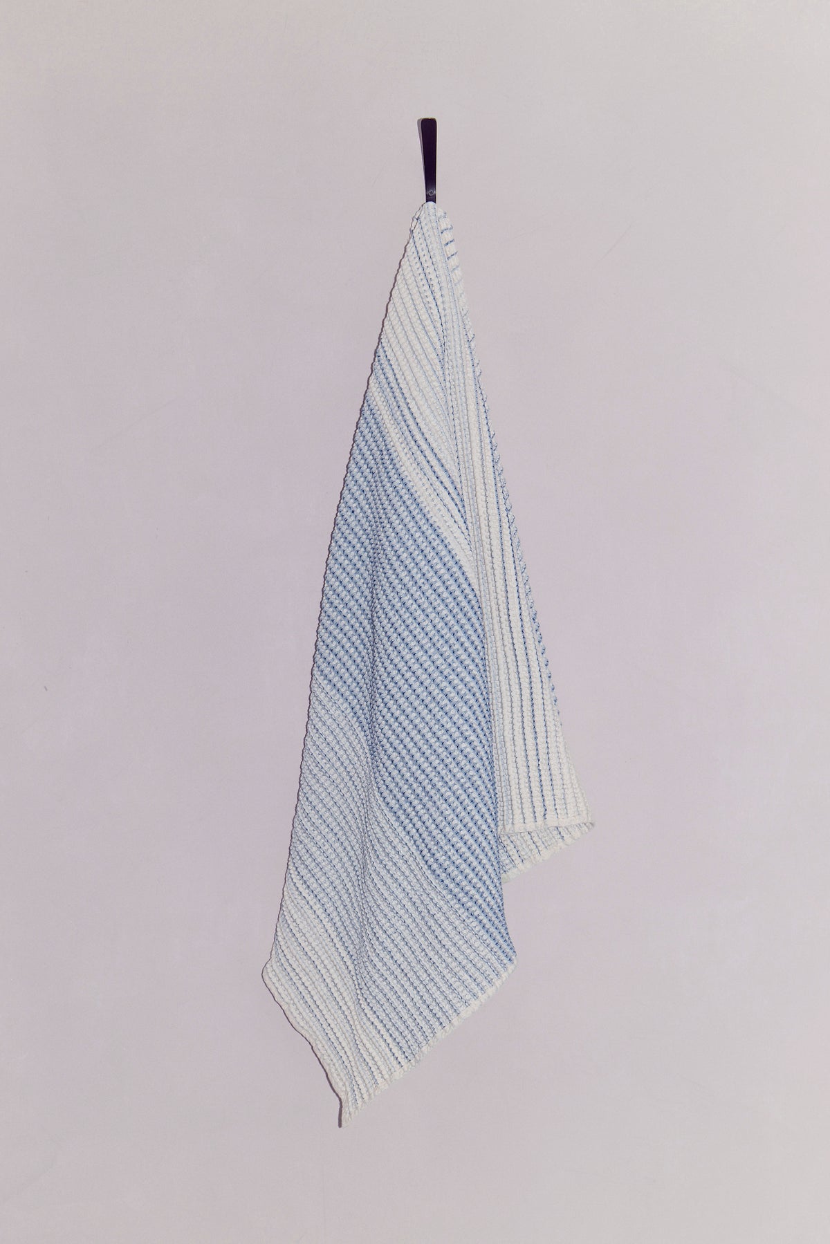 Draped cotton waffle towel on neutral wall