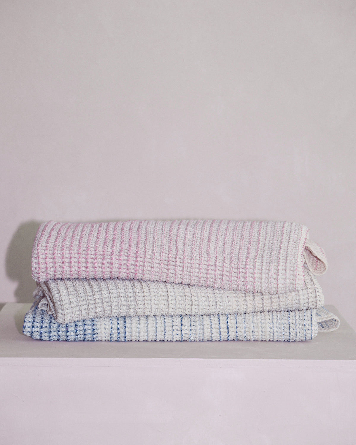 Stacked baby towels in Sand, shell, and tide highlighting absorbent natural fibers