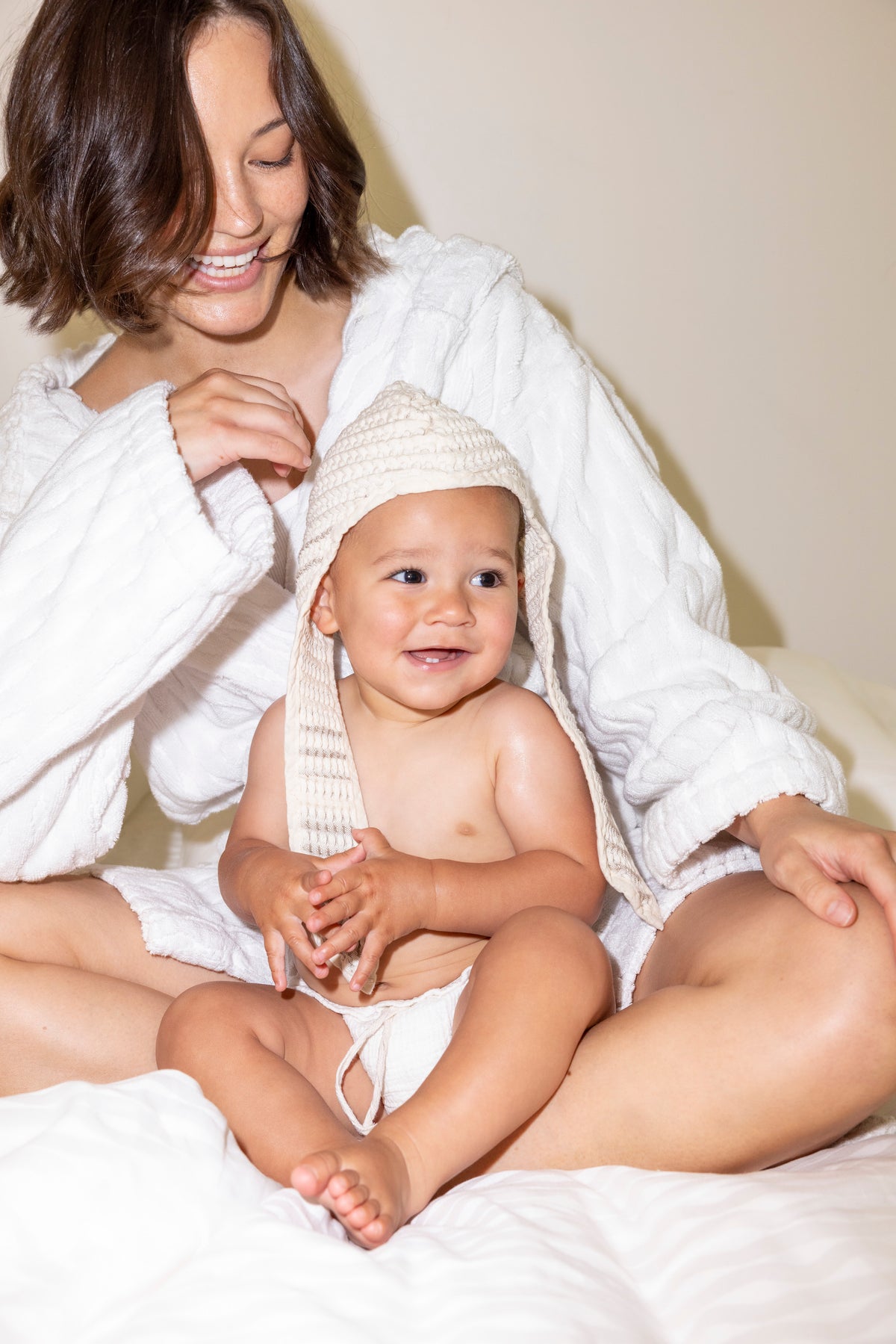 Mother and baby after bath in pure natural linen cotton textiles, joy